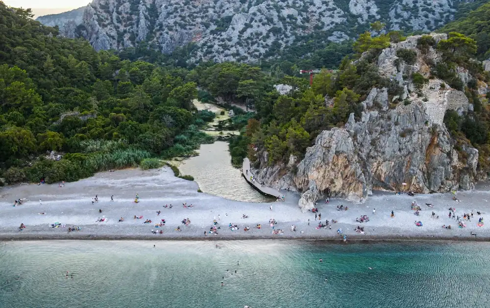 Olympos Antik Kenti ve antik kent içerisinden geçen akarsu ve etrafını çevreleyen çam ormanları ile birlikte olympos plajının havadan görünümü