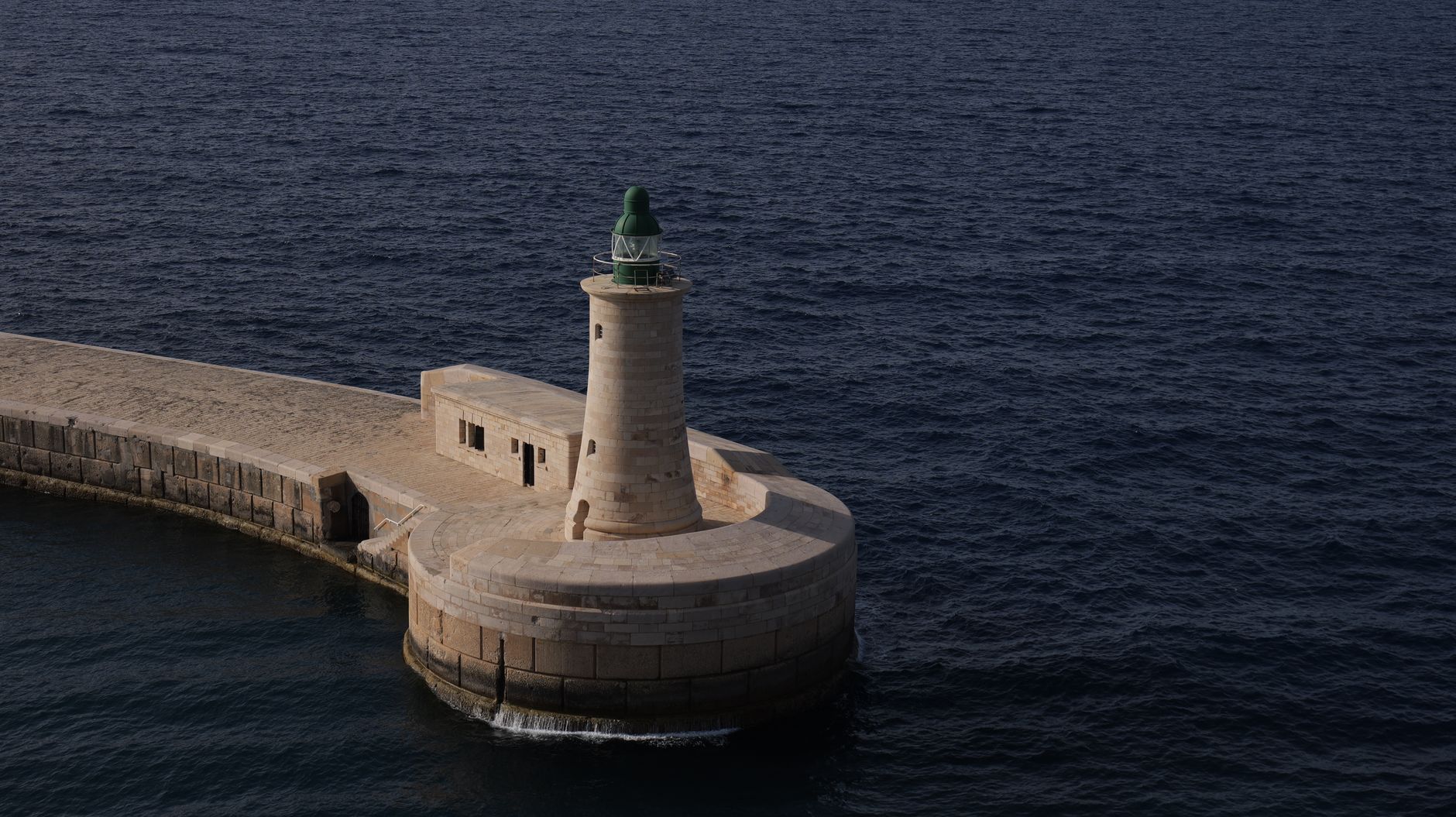 Malta’nın tarihi sokaklarında gezen insanlar ve deniz manzarası